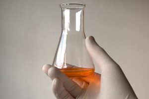 beaker of fake urine held by a lab tech