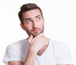 young thinking man looks up in casual cloths