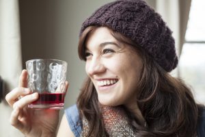 young woman drinking glass of cranberry juice