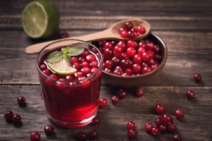 Cranberry juice with mint on old wooden table