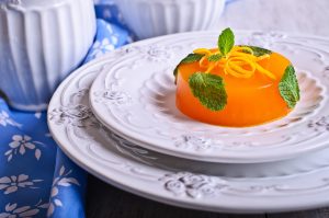 Jelly orange with green leaves on a beautiful mint plate