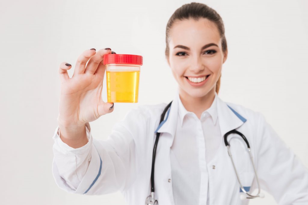 smiling doctor holding a urine sample